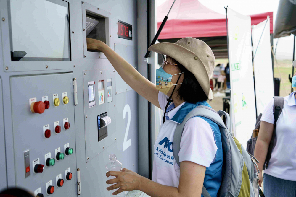 志工們將拾起的寶特瓶投入「好歸塑專車」，讓廢棄塑料空瓶可以直接粉碎、縮小體積，未來將可再製成購物袋、寶特衣、悠遊卡等生活用品